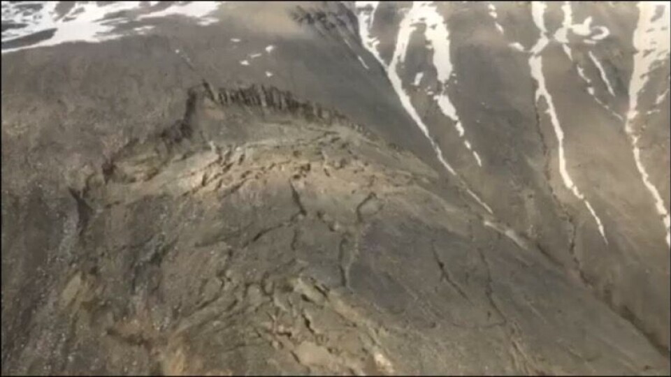 Det nyeste billede af det omtalte klippestykke der er i høj fare for at styrte mod havet. Billedet viser tydeligt, hvordan store stykker har løsrevet sig fra fjeldet. De løsrevne klippestykker ligger 1 km. fra det klippeskred, der forårsagede flodbølgen i weekenden.