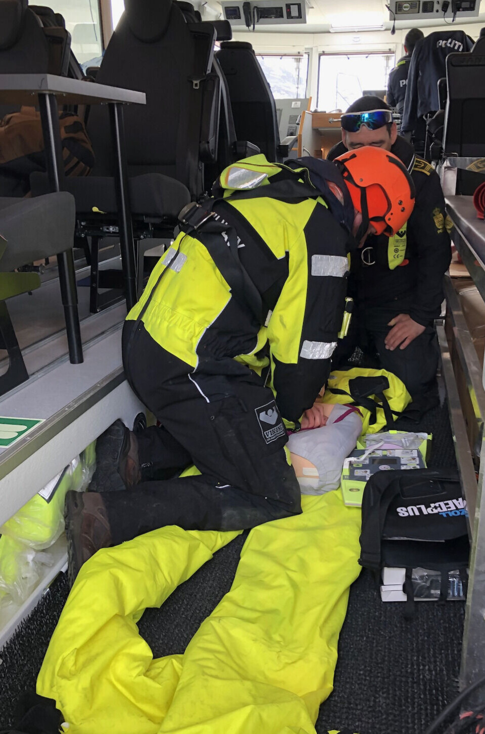 Den bjærgede partient modtager behandling fra en af Knud Rasmussens besætningsmedlemmer.