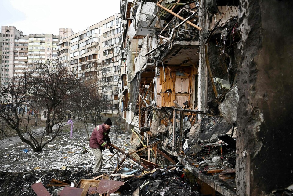 En mand rydder affald ved en beskadiget beboelsesbygning ved Koshytsa Street, en forstad til den ukrainske hovedstad Kiev, hvor en militærgranat angiveligt ramte, den 25. februar 2022.