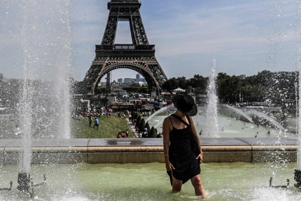 En kvinde køler ned i et springvand nær Eiffeltårnet i den franske hovedstad, Paris.