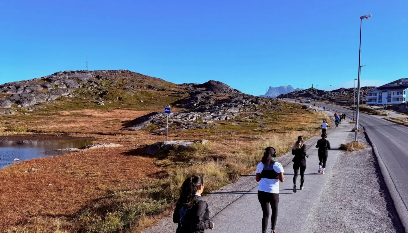 The runners on their way through Nuuk's varying terrain and late summer sun.