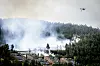 Et helikopter deltager i slukningsarbejdet over det omfattende brandområde i Drammen, Norge, hvor omkring 100 boliger blev ødelagt af flammerne.