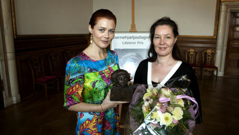 Skuespilleren Sofie Lassen Kahlke, der er ambassadør for Børnehjælspdagen overrækker checken til Foreningen Grønlandske børn. Foto: Polfoto