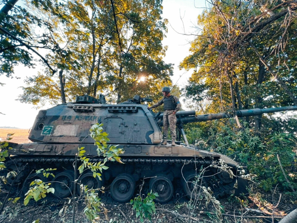 En ukrainsk soldat står på et efterladt russisk militærkøretøj i den generobrede Kharkiv-region.