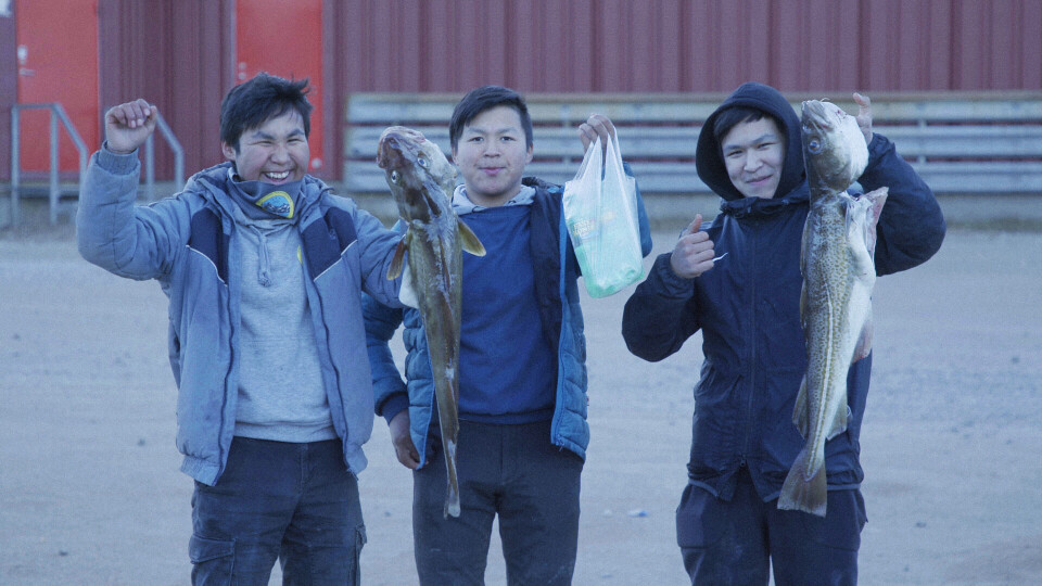 Drenge med fisk foran butikken