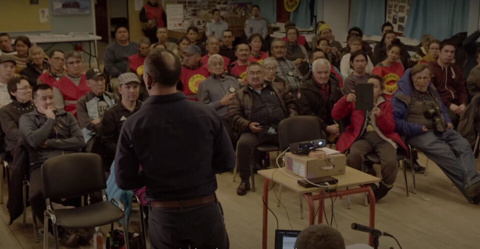 I dokumentarfilmen ”” vises blandt andet klip fra borgermødet i Narsaq i februar 2021, hvor Kalistat Lund blandt stiller kritiske spørgsmål fra tilskuerrækkerne. Dengang var han iført en rød Urani Naamik vest. I dag er han ansvarlig for hele miljøområdet. White Paper