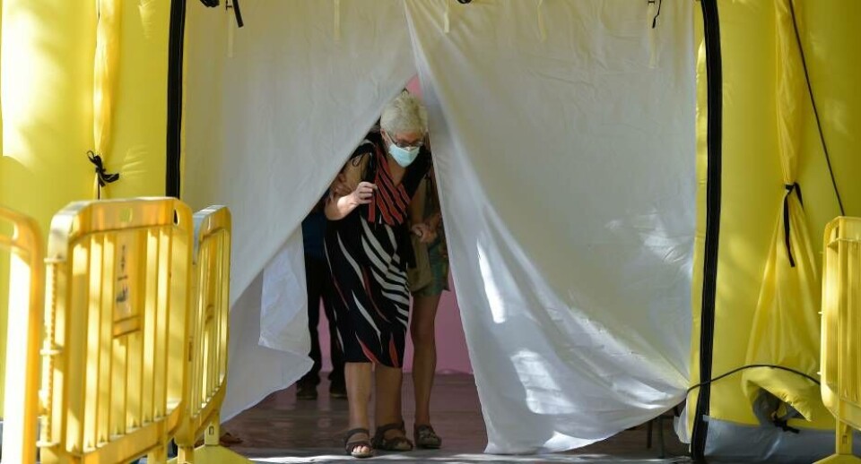 En spansk kvinde forlader her et center, hvor man kan blive testet for coronavirus.