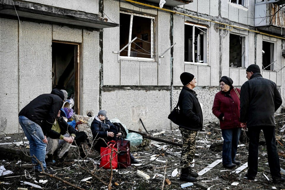 Folk står uden for en bomberamt bygning i byen Chuguiv i det østlige Ukraine.