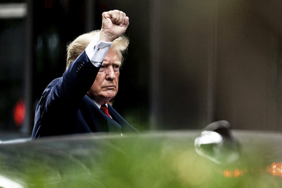 En trodsig Donald Trump foran Trump Tower i New York inden han onsdag mødte op hos den offentlige anklager, der undersøger sag om kreativ bogføring af ejendomme i Trump Organization.