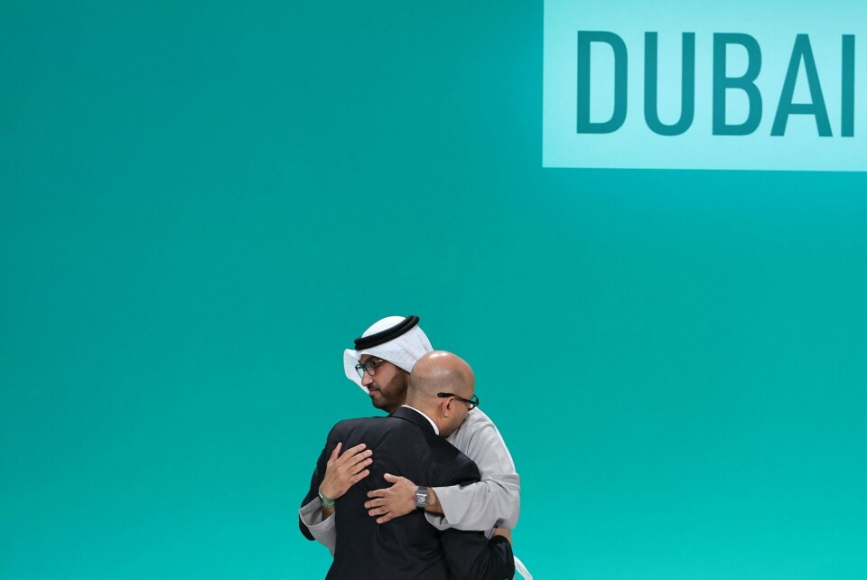 COP-formand Sultan al-Jaber (til højre) og FN's klimachef Simon Stiell (til venstre) ses her i en omfavnelse, efter at en aftale onsdag blev vedtaget.