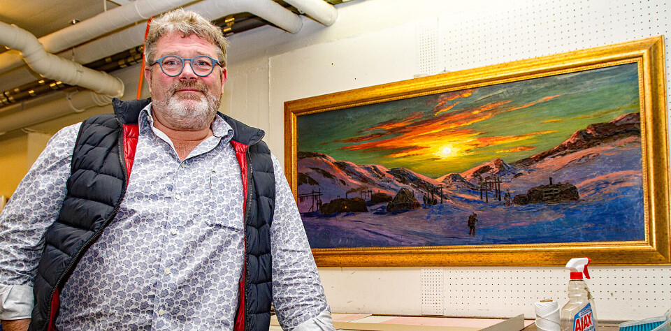 Kent Wolfsen på værkstedet i Galleri Inuit. På væggen hænger der selvfølgelig et maleri af grønlandsmaleren Emanuel Petersen.
