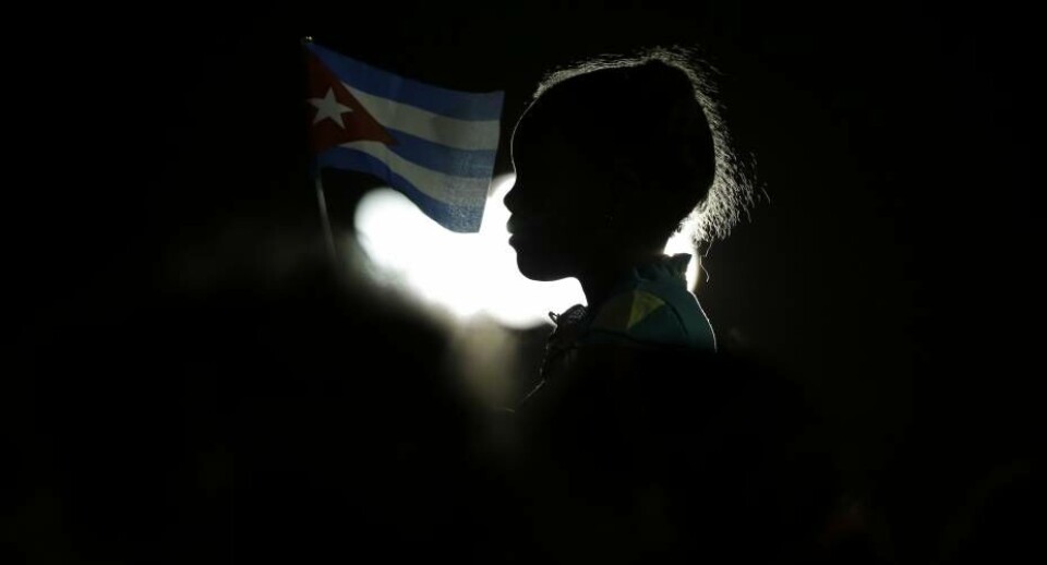 En pige holder det cubanske flag, da Fidel Castros aske ankommer til Santiago de Cuba
